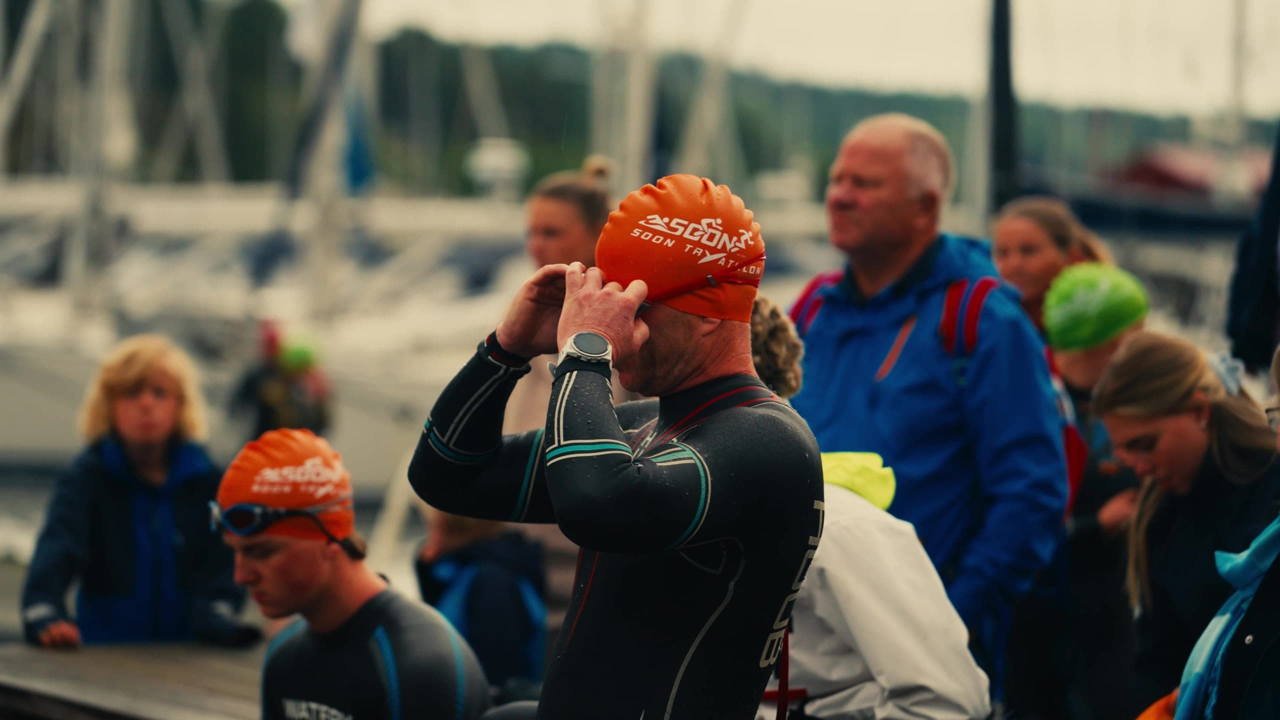 Deltaker i våtdrakt og oransje badehette fra Soon Tryathlon gjør seg klar til svømmingen